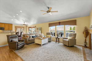Living room with ceiling fan, plenty of natural light, a textured ceiling, recessed lighting, and light wood-style flooring