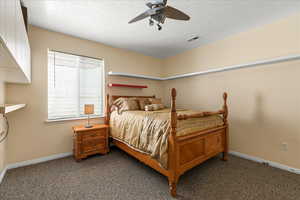 Carpeted bedroom featuring baseboards and ceiling fan