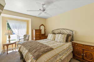 Carpeted bedroom featuring baseboards and ceiling fan