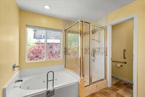Full bathroom with a stall shower, a jetted tub, healthy amount of natural light, and recessed lighting