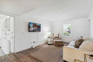 Living room featuring wood finished floors and tall colonial baseboards