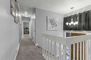 Entry and hallway with chandelier and window coverings