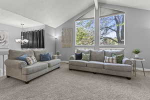 Carpeted living area with a brick fireplace, textured ceiling, and large windows