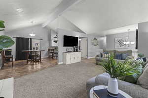 Carpeted living area with a brick fireplace, textured ceiling, and large windows