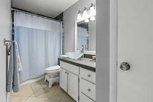Bathroom featuring vanity, toilet, tile flooring, and shower / bath combo