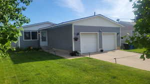 Single story home with a garage, a front yard, and entry.