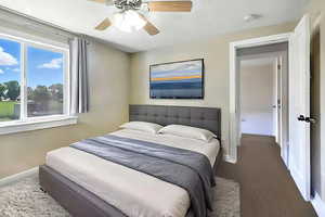 Virtually Staged Photo: Bedroom featuring carpet flooring, multiple windows, and a ceiling fan