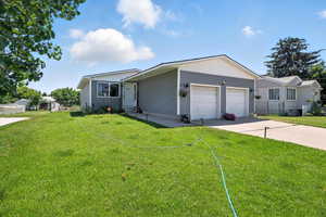 Single story home featuring concrete driveway, a garage, and a front lawn