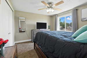 Bedroom featuring carpet floors, ceiling fan, and a closet