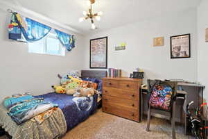Bedroom featuring carpet flooring and a chandelier