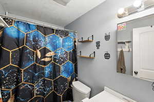 Bathroom featuring a shower with shower curtain and vanity