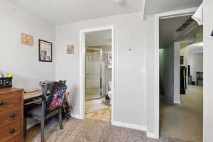 Home office with light carpet and baseboards