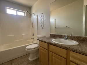 Bathroom featuring toilet, vanity, shower / tub combination, and tile patterned floors