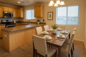 Kitchen featuring appliances with stainless steel finishes, a sink, dark countertops, light tile patterned flooring, and recessed lighting
