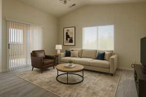 Living room with lofted ceiling, baseboards, and light colored carpet