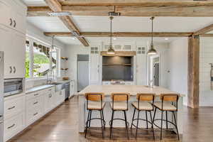 Kitchen with a sink, stainless steel appliances, beam ceiling, dark wood finished floors, and white cabinets