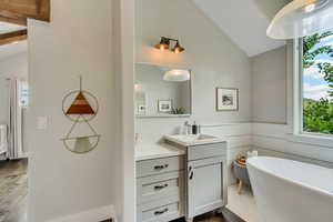 Master Full bathroom featuring plenty of natural light, wood finished floors, vanity, and a freestanding tub