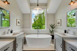 Master Full bathroom with two vanities, a freestanding tub, and healthy amount of natural light