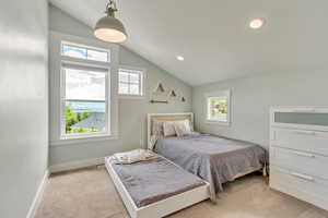 Bedroom with light colored carpet, vaulted ceiling, baseboards, and recessed lighting