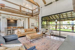 Living room with a towering ceiling, healthy amount of natural light, and beamed ceiling