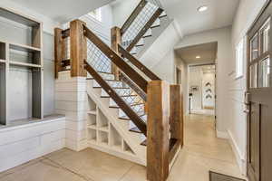 Stairway with recessed lighting and healthy amount of natural light