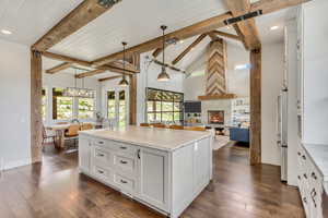 Kitchen with open floor plan, healthy amount of natural light, a fireplace, an island with sink, and recessed lighting