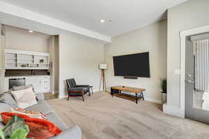 Living area featuring light colored carpet, baseboards, and recessed lighting