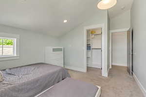 Bedroom with light carpet, lofted ceiling, baseboards, a spacious closet, and recessed lighting