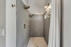 Master Full bath featuring tiled shower with two shower heads