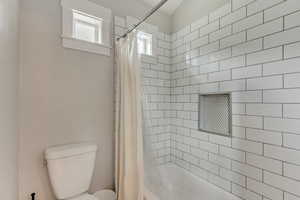 Bathroom with toilet and shower / bath combo