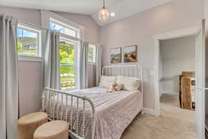 Carpeted bedroom featuring vaulted ceiling and baseboards