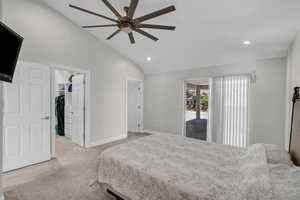 Bedroom with lofted ceiling, light carpet, a walk in closet, recessed lighting, and baseboards
