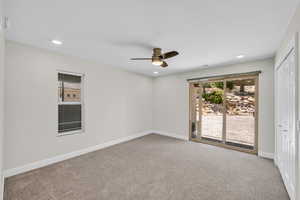 Carpeted empty room featuring a ceiling fan, baseboards, and recessed lighting