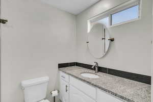Half bathroom featuring toilet and vanity