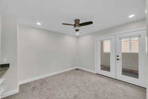 Carpeted empty room featuring french doors, ceiling fan, baseboards, and recessed lighting