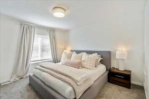 Bedroom with a textured ceiling and carpet flooring