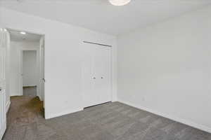Unfurnished bedroom featuring carpet flooring and baseboards