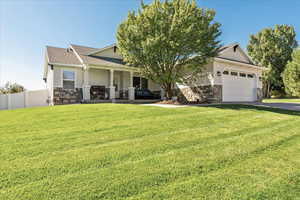 Craftsman inspired home with stone siding, stucco siding, covered porch, an attached garage, and roof with shingles
