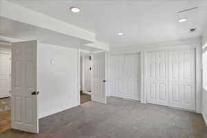 Unfurnished bedroom with two closets, carpet floors, recessed lighting, and baseboards