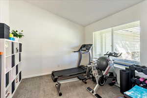 Exercise area featuring carpet floors and lofted ceiling