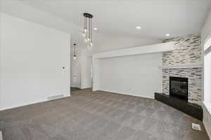 Unfurnished living room with lofted ceiling, carpet, a tile fireplace, recessed lighting, and baseboards