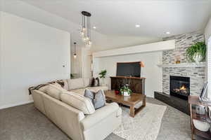 Living room with vaulted ceiling, carpet, a large fireplace, and recessed lighting