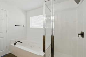 Bathroom featuring a stall shower and a tub with jets