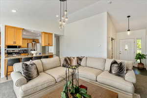 Living room with recessed lighting, a chandelier, and high vaulted ceiling