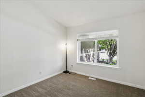 Carpeted empty room featuring baseboards