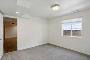 Unfurnished room featuring carpet, baseboards, and a smoke detector