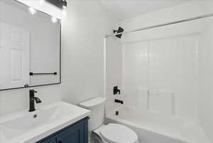 Full bath with vanity, toilet, and  shower combination