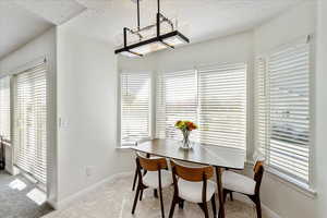 Dining room with a textured ceiling and baseboards