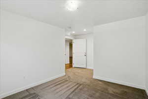Unfurnished room featuring light colored carpet, baseboards, and recessed lighting