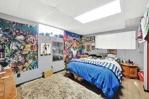 Bedroom featuring a drop ceiling and wood finished floors
